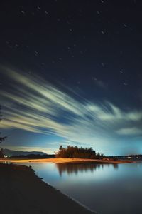 Scenic view of lake against sky at night