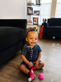 Portrait of cute girl playing with teddy bear at home