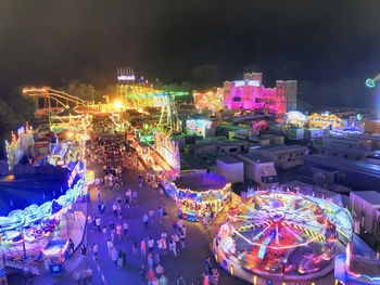 Illuminated ferris wheel in city at night