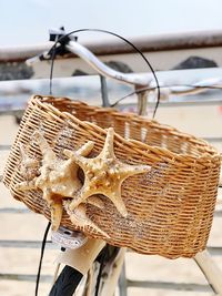 Close-up of bicycle in basket on beach