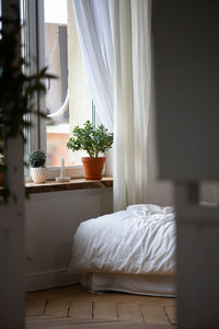 Bedroom the bed is a little crumpled the blanket by the window with a view of the street looks