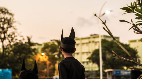 Rear view of boy wearing horn mask against clear sky