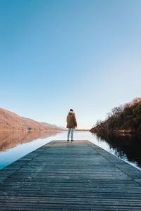 Man on jetty on lake mergozzo in winter