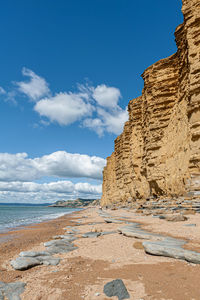 Rock formation on beach against sky