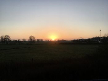 Scenic view of field against clear sky during sunset