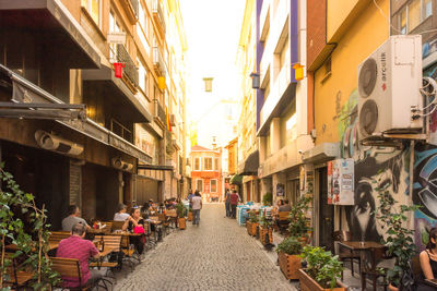 People walking on street amidst buildings in city