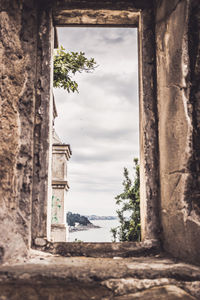 Old building by trees against sky