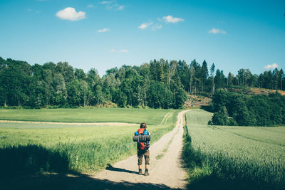 Rear view of boy walking on footpath