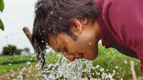 Close-up of man washing face