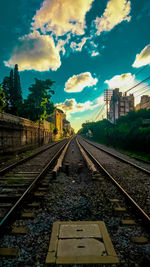 Railroad tracks against cloudy sky