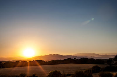 Scenic view of lake with trees and mountains at dusk