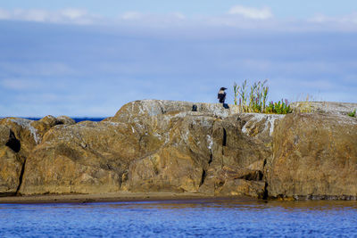 Rock formations by sea against sky