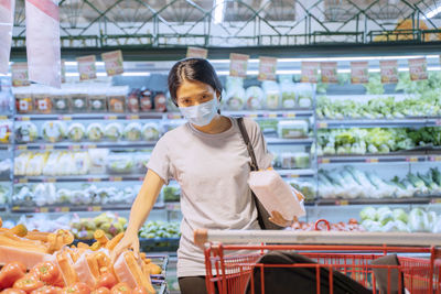 Portrait of woman wearing mask standing in shopping mall