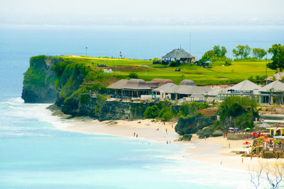 Scenic view of beach by buildings against sky