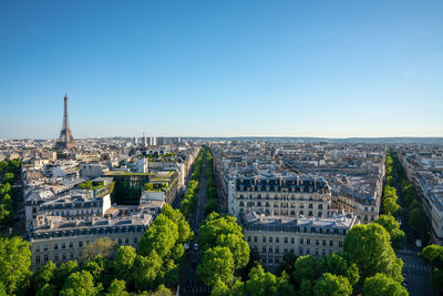 Aerial view of buildings in city against clear blue sky