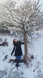 Full length of woman standing on snow covered field