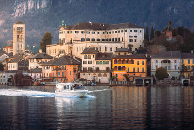 Buildings by river against sky