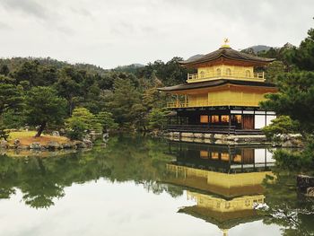 Reflection of building on lake against sky