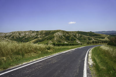 Empty road along countryside landscape