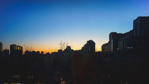 Cityscape against clear sky during sunset