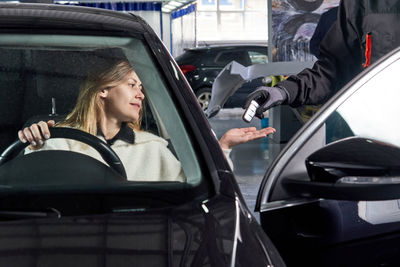 Mechanic giving car key to customer