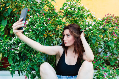 Photo of adorable young woman making selfie outdoors backyard