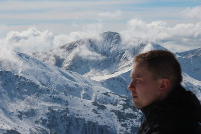 Portrait of man against snow covered mountains