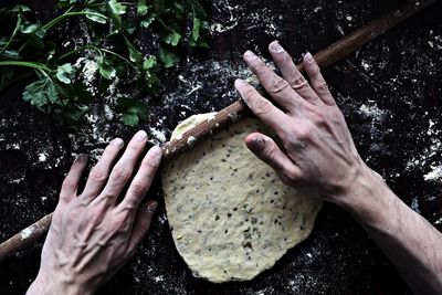 Close-up of hands rolling dough