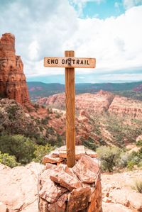 Information sign on rock against sky