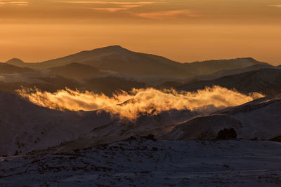 Scenic view of snowcapped mountains against sky during sunset