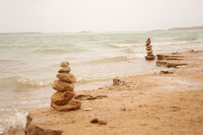 Stack of rocks on beach against sky