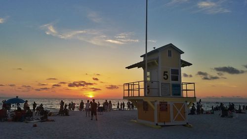 People at beach during sunset