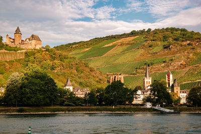 Scenic view of river by building against sky