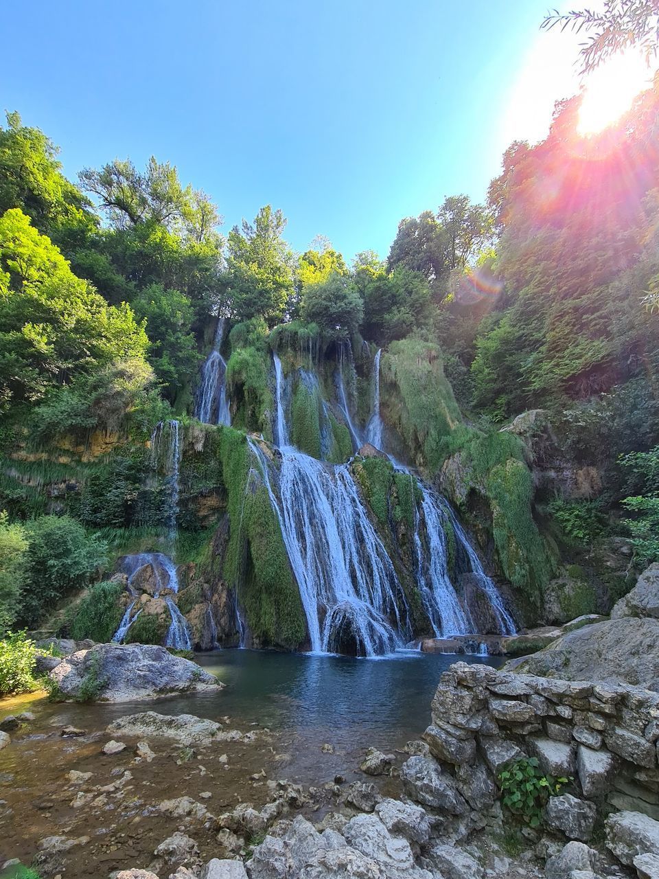 SCENIC VIEW OF WATERFALL AGAINST SKY