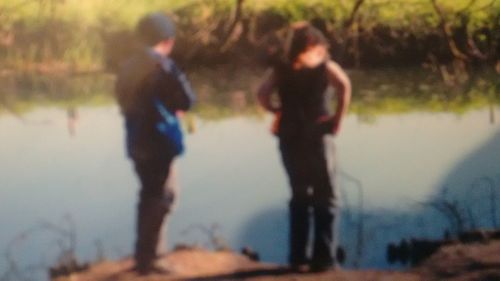 Rear view of people walking in water