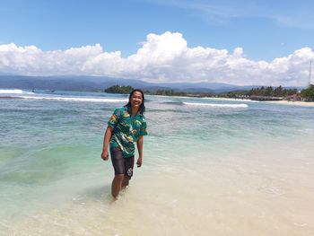 Portrait of young man standing at beach