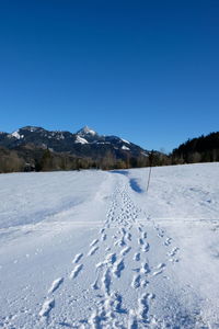 Scenic view of snowcapped mountains against clear blue sky