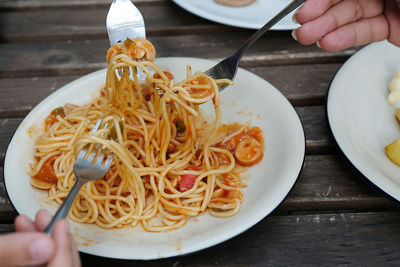 Midsection of person having food in plate on table