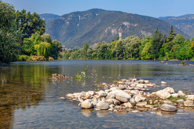 Brenta river and alps in bassano del grappa in italy . scenery with rocks in the flowing water