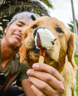 Close-up of man with dog eating outdoors
