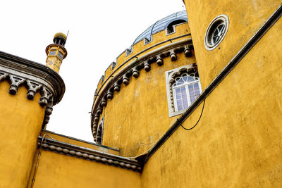 Low angle view of yellow building against sky