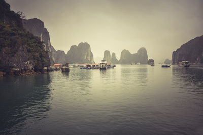 Boats in sea against sky during sunset