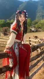 Portrait of young woman standing on field