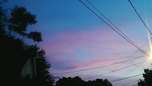 Low angle view of power lines against sky