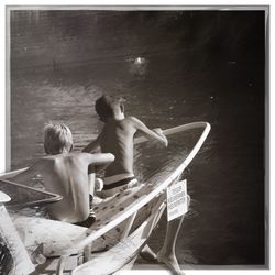Rear view of friends sitting on boat in water