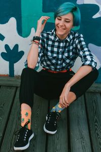 Full length of smiling man sitting on seat