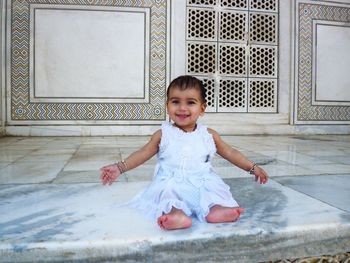 Portrait of cute girl smiling on floor at home