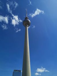 Low angle view of communications tower against blue sky