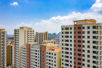Buildings in city against cloudy sky
