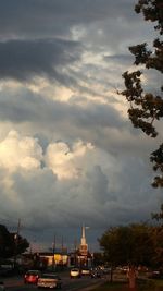 Cars on road against cloudy sky